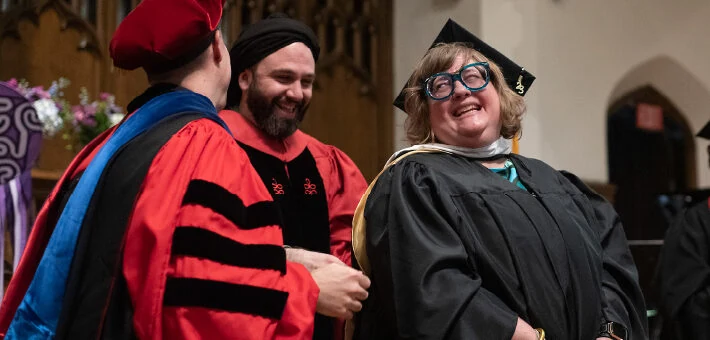 A graduate receives her hood during Commencement.