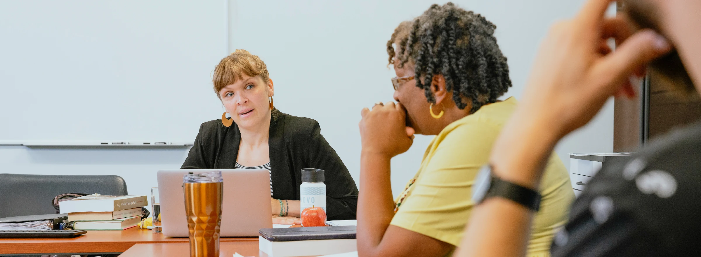 A professor and students at a table.