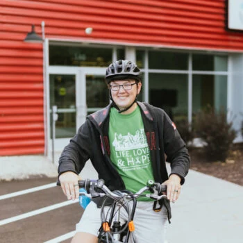 A photo of student on a bike.