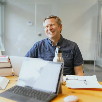 A staff member smiles at a student.