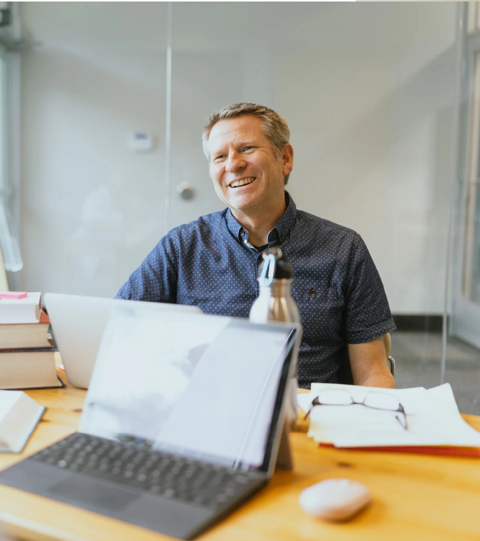 A staff member smiles at a student.