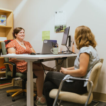 Our Director of Admissions speaks with another staff member in her office.