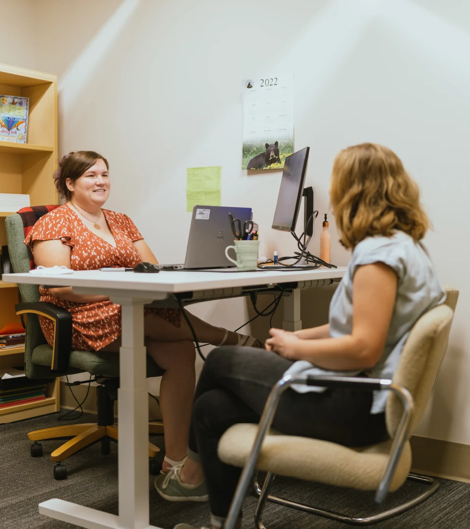 Our Director of Admissions speaks with another staff member in her office.