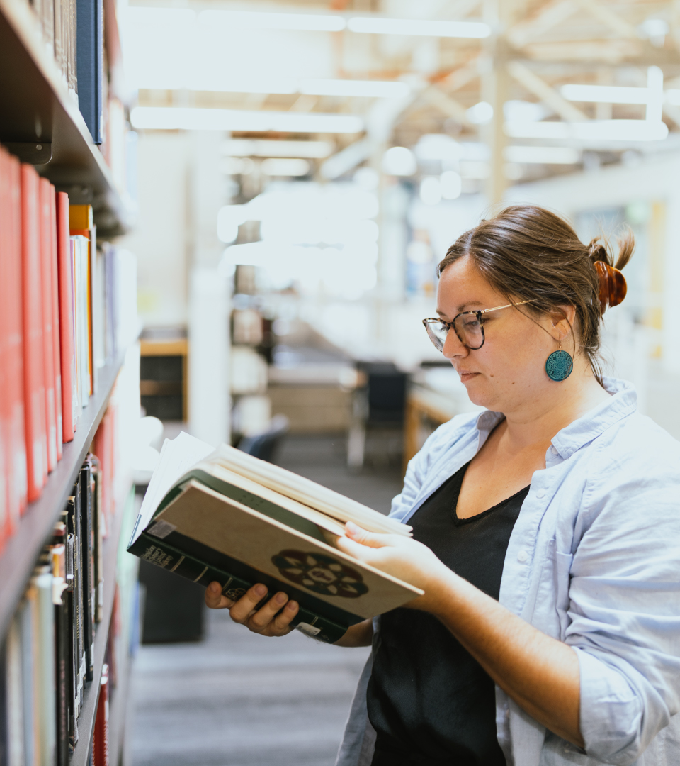 A student reads a book in the library.