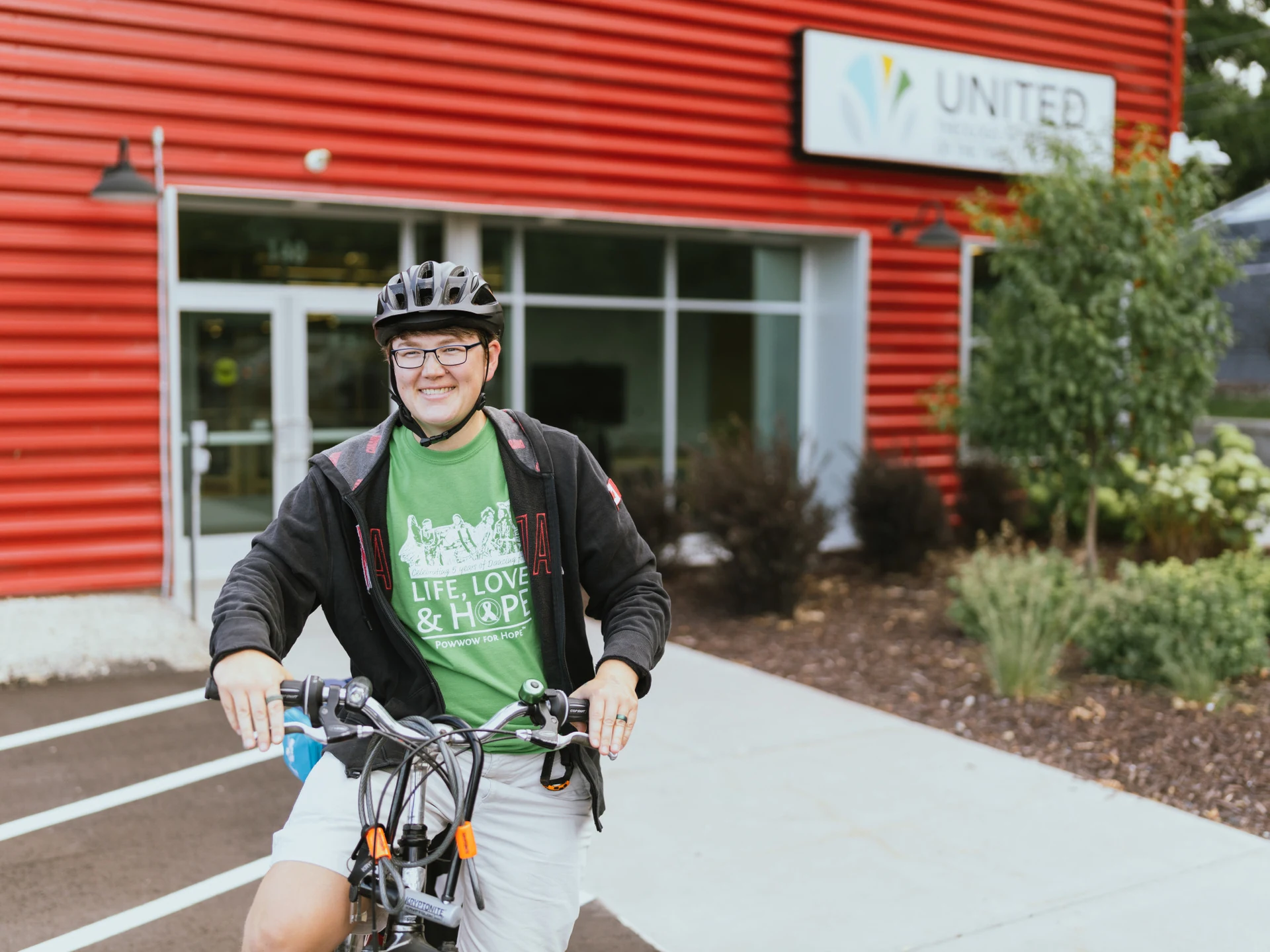 A photo of a student on a bike outside of the main entrance.